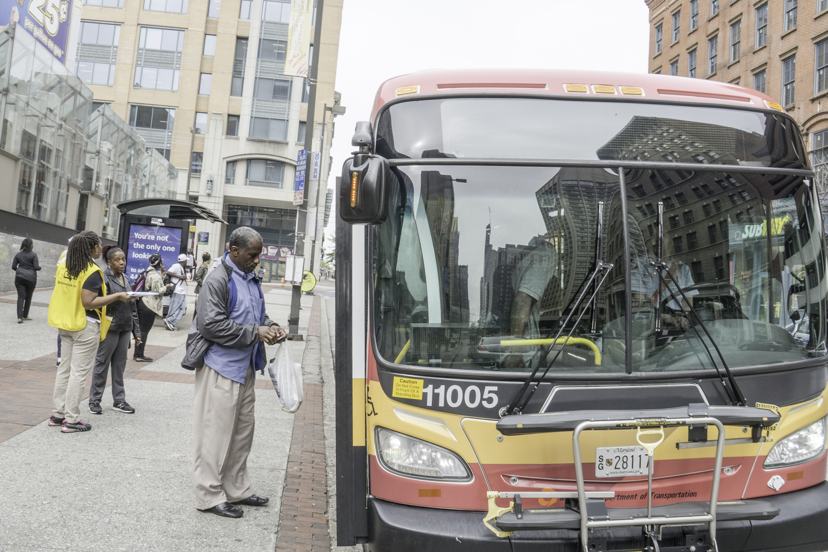 Photo of commuter boarding a bus operated by the Maryland Department of Transportation