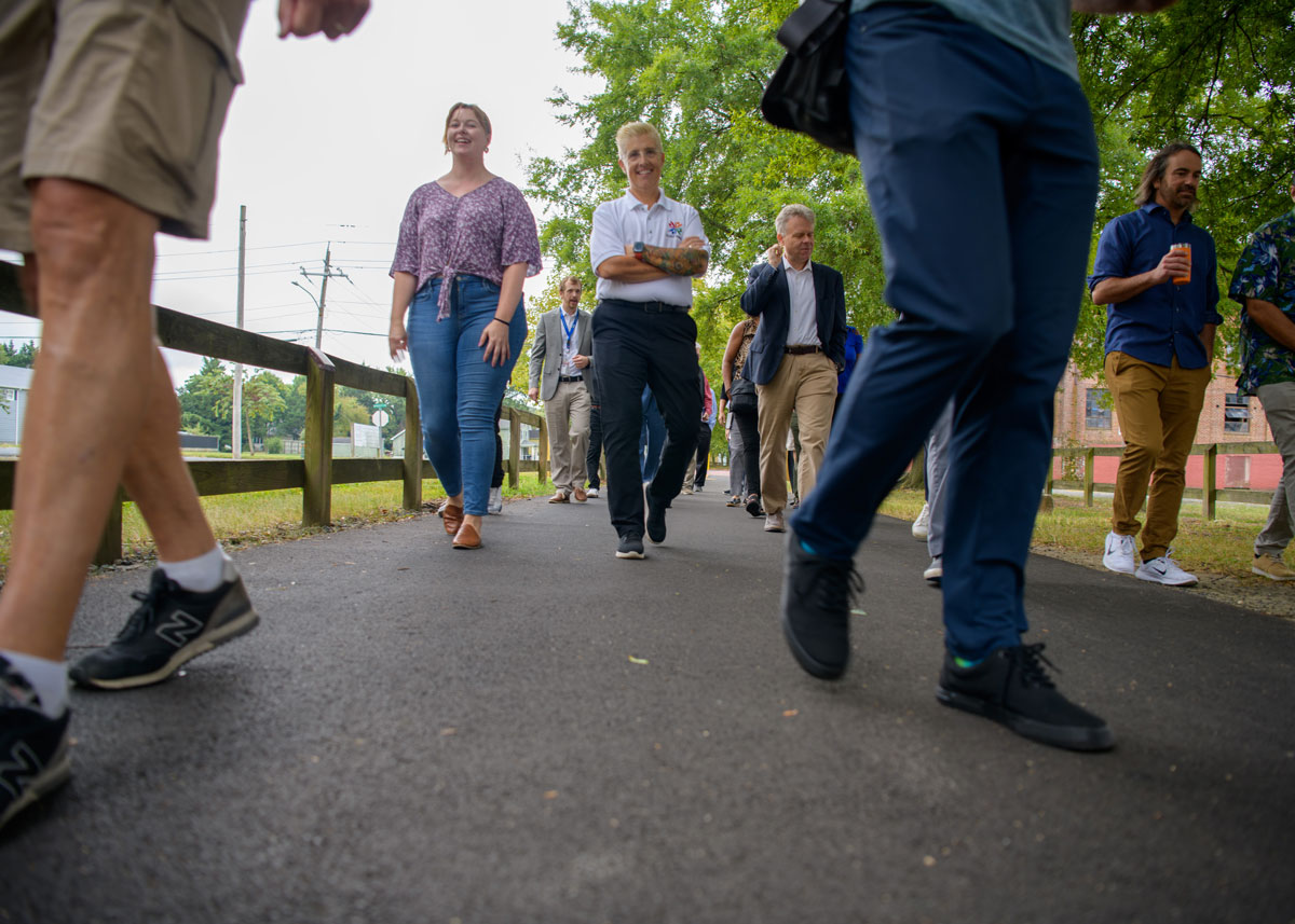 Image of a group of people walking happily on a paved path